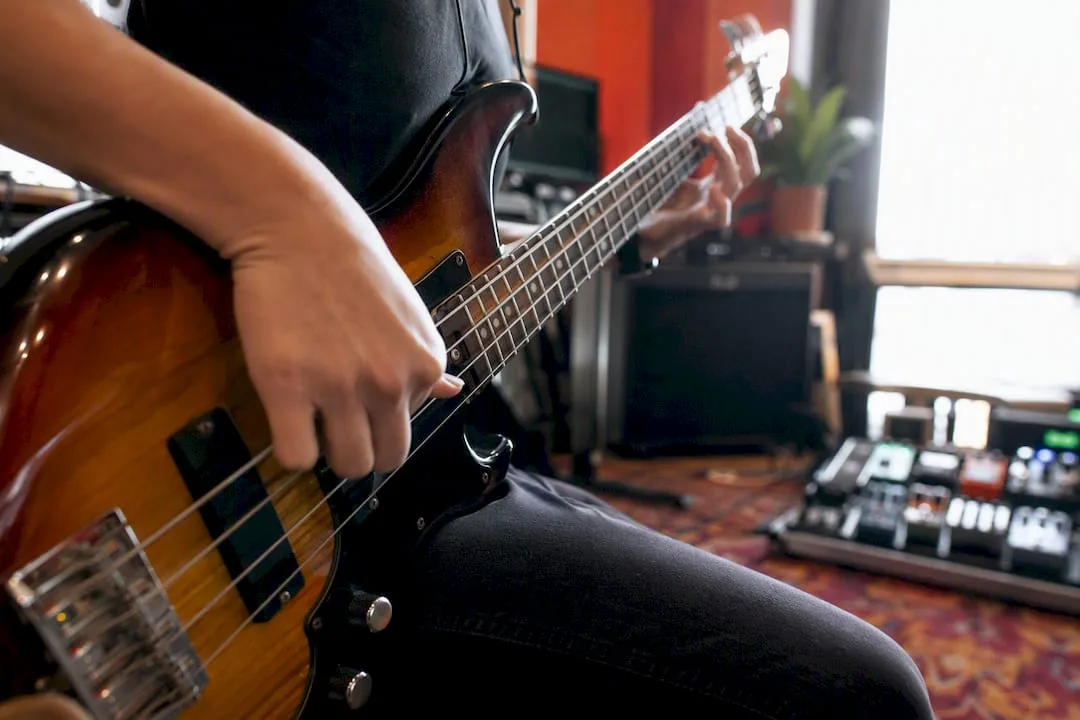 Rechterhand van een basgitaar die slap- en popbewegingen maakt