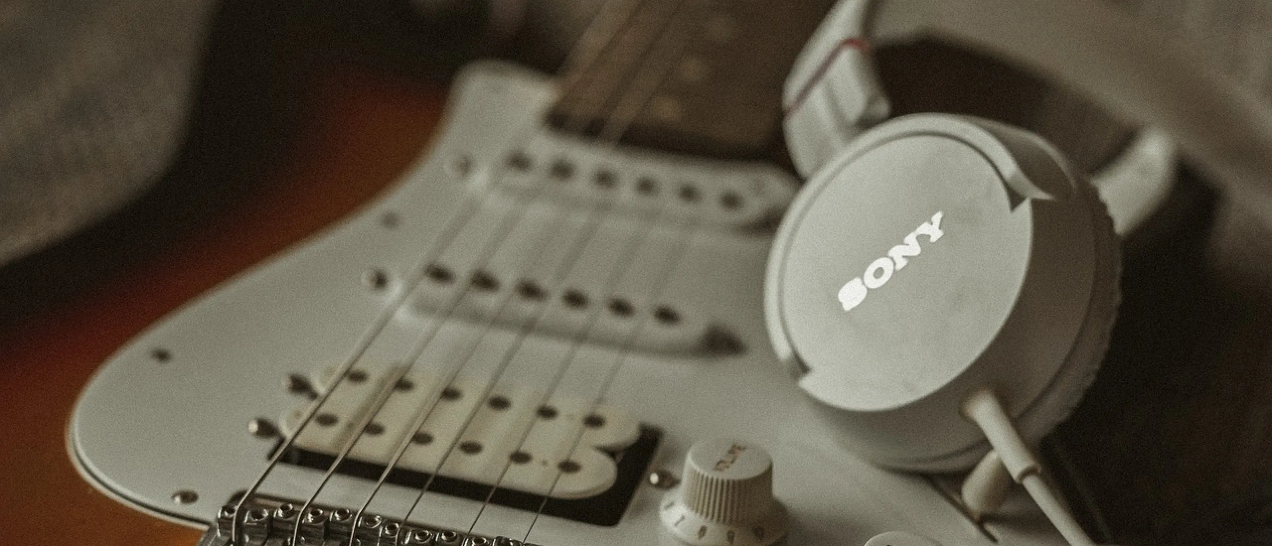 Kan ik een koptelefoon aansluiten op mijn basgitaar?